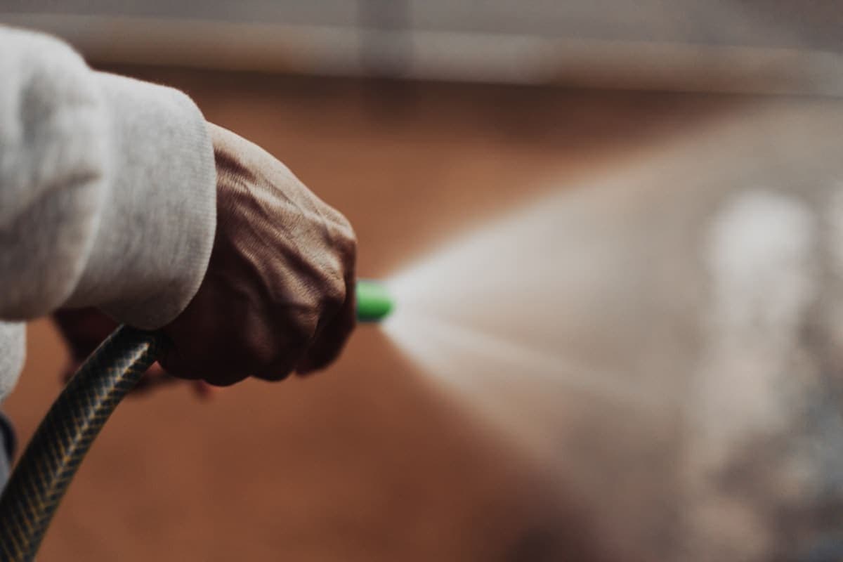 Pest control technician checking Houseler on a phone in a work truck